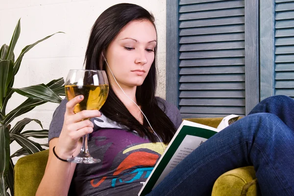 Милая девушка пьет во время чтения книги — стоковое фото