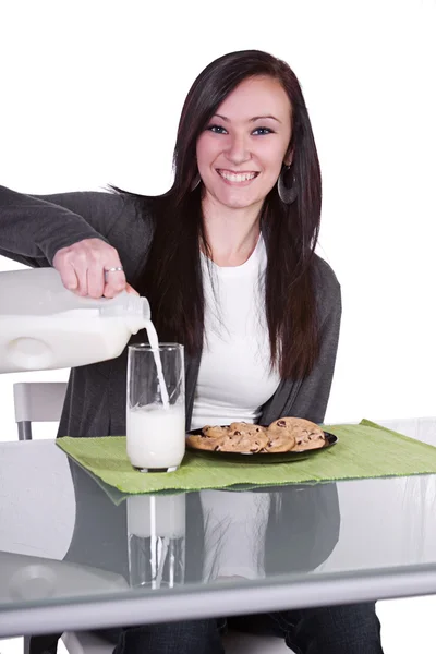 Девочка наливает молоко в стакан — стоковое фото