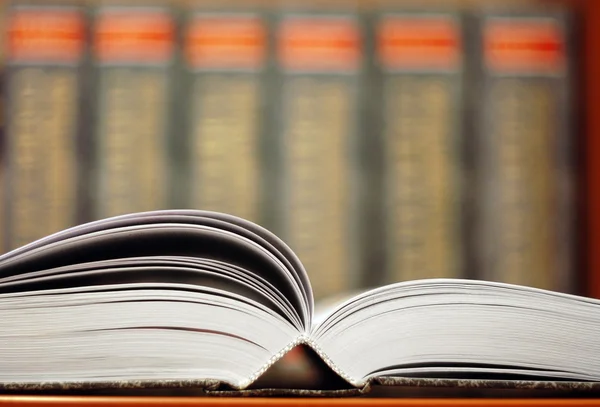 stock image Opened book with bookshelf background