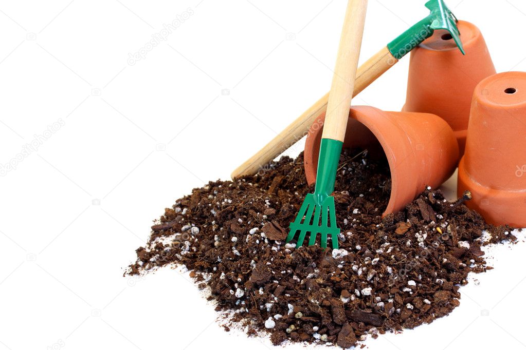 Clay flower pots, soil and a rake
