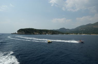 Powerboats in the sea against coast clipart