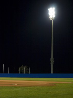 Baseball field at night under spotlight clipart