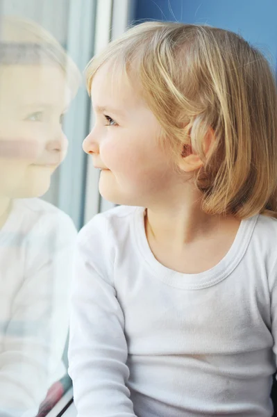 Mädchen sitzt am Fenster — Stockfoto