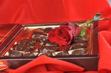 Chocolates and rose on red