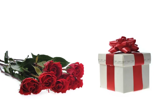 Красивые красные розы и подарок — стоковое фото