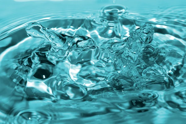 Gotas de água entram na água — Fotografia de Stock