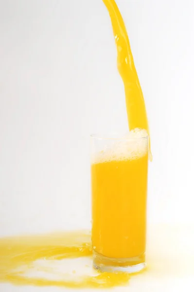 Vazamento de suco de laranja em vidro — Fotografia de Stock