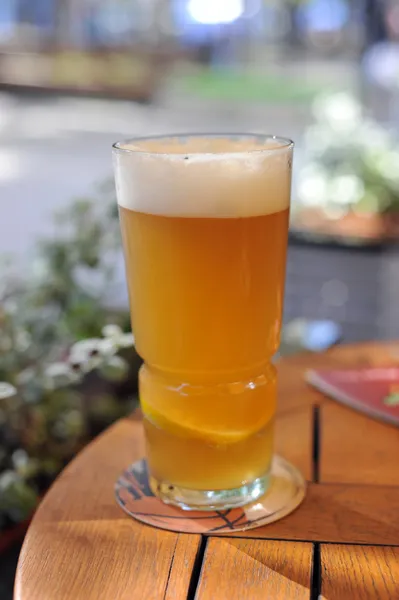 Пиво с лимоном на столе — стоковое фото