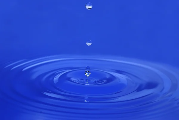 Wassertropfen gelangen ins Wasser — Stockfoto
