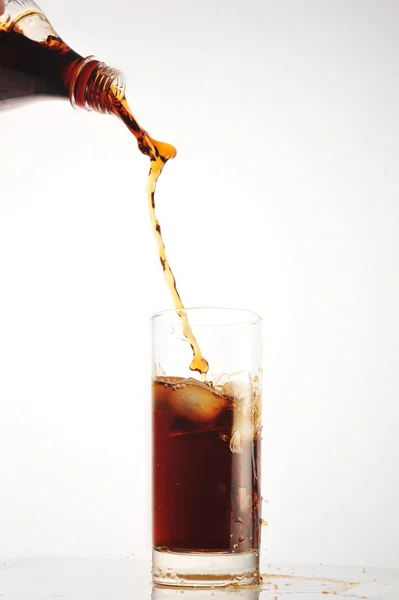 Cola giet in glas op wit — Stockfoto