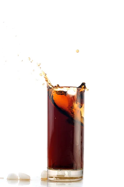 Eis fällt in Cola mit Spritzer — Stockfoto