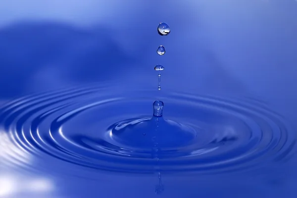 Gotas de agua entra en el agua — Foto de Stock