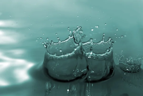 Waterdruppels treedt in water — Stockfoto