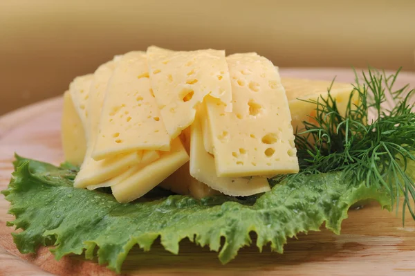 Нарезанный желтый сыр с салатом — стоковое фото