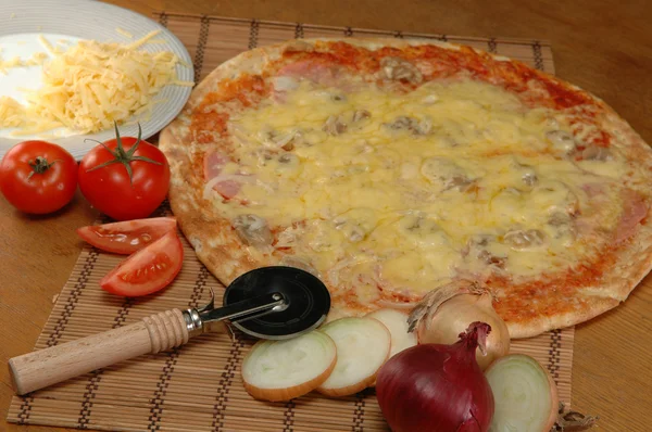 Pizza liggande på bordet — Stockfoto