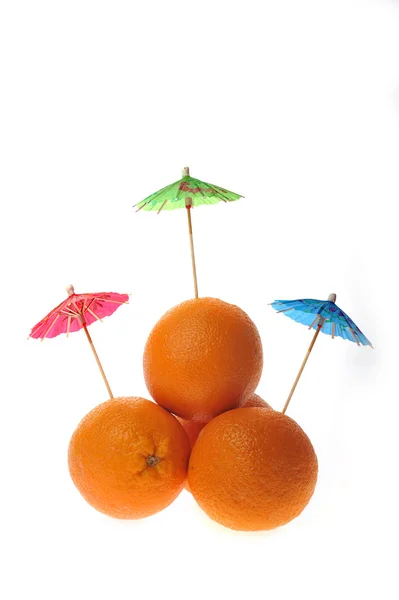 Apelsiner med coctail paraplyer isolerad på vit — Stockfoto
