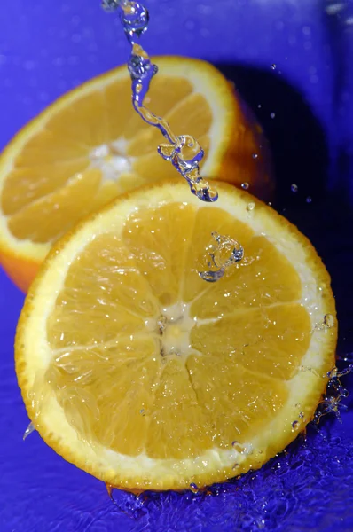 Vatten droppar på skivad apelsin — Stockfoto