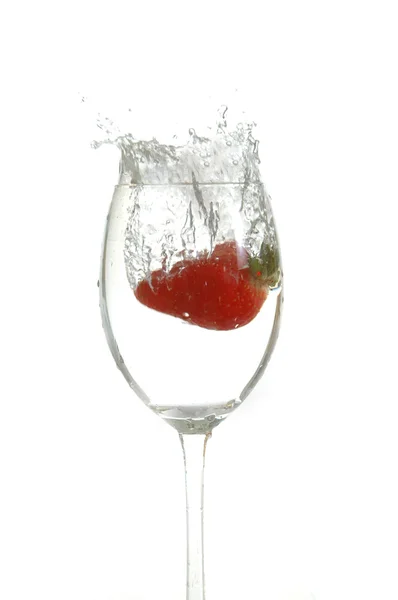 Strawberry drop into glass — Stock Photo, Image