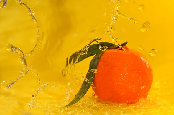 Salpicaduras de mandarina y agua —  Fotos de Stock