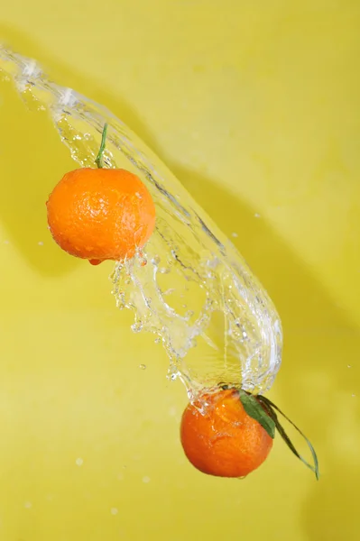 Два мандарини і бризки води — стокове фото