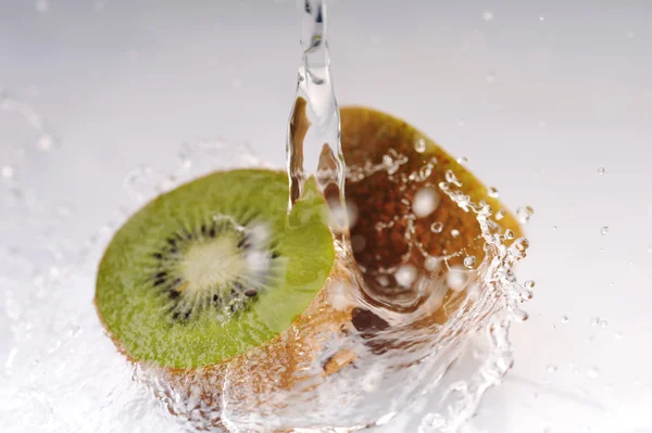 Cuted kiwi met opspattend water — Stockfoto