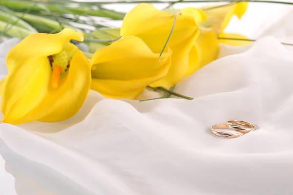 Gelbe Calla-Lilien und Trauringe — Stockfoto