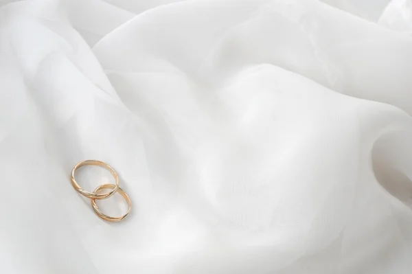 Tecido branco e anéis de casamento — Fotografia de Stock