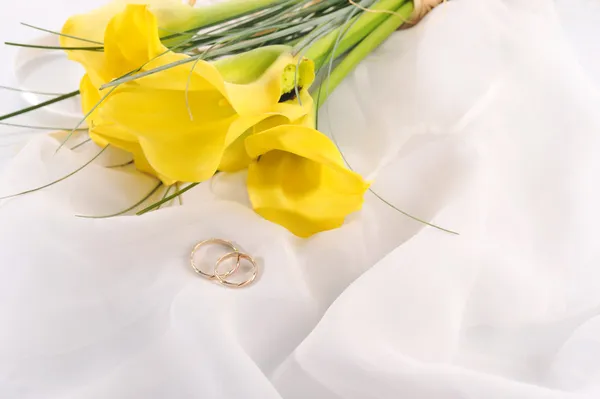 Gele calla lelies en trouwringen — Stockfoto