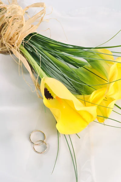 Yellow calla lilies and wedding rings — Stock Photo, Image