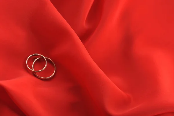 Tecido vermelho e anéis de casamento — Fotografia de Stock
