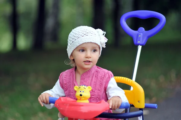 Маленькая девочка с трехколесным велосипедом — стоковое фото