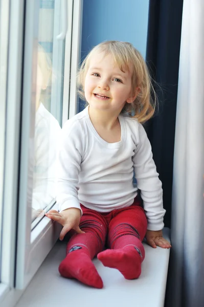 Dívka sedí u okna — Stock fotografie
