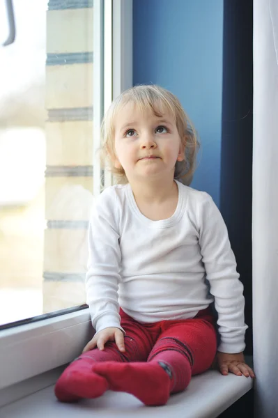 Flickan sitter vid fönstret — Stockfoto