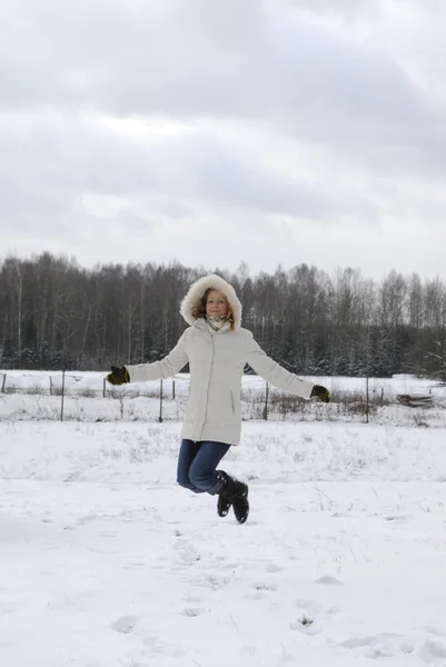Jumping girl wearing winter coat — Stock Photo, Image