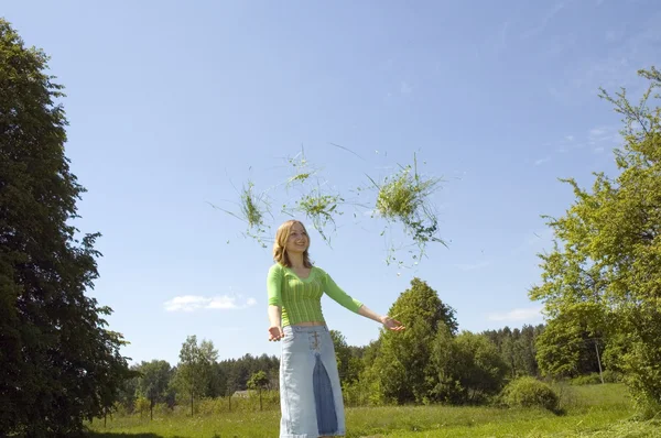 Chica lanzando hierba —  Fotos de Stock