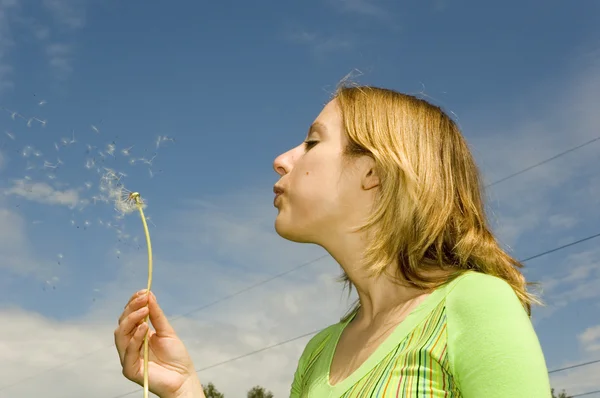 Girl blowing dandelion — Stock Photo, Image