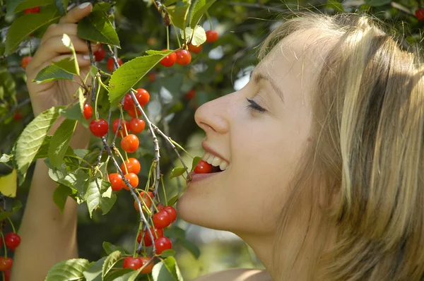 Leuk meisje in de tuin met cherry — Stockfoto