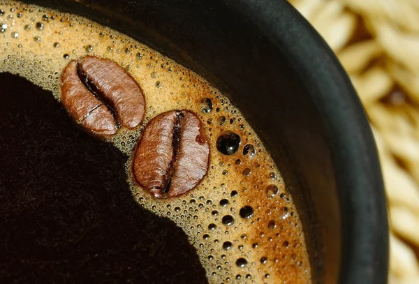 Kopje zwarte koffie en koffie bonen — Stockfoto