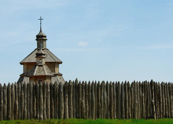 Wooden stockade and a church — Stock Photo, Image