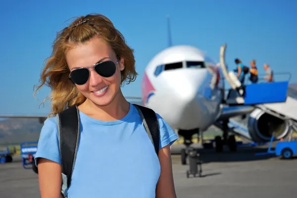 Młoda kobieta przed samolotem. — Zdjęcie stockowe