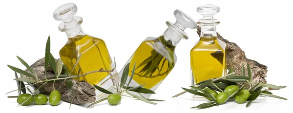 Trzy butelki oleju z oliwek i oliwki. — Zdjęcie stockowe