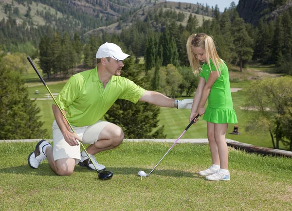 父亲和女儿高尔夫课 免版税图库照片