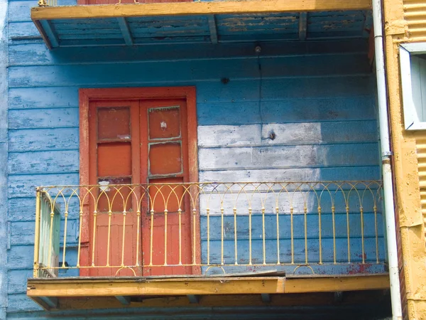 Helder oranje deur naar de opslageenheid in helder blauwe gebouw Stockafbeelding