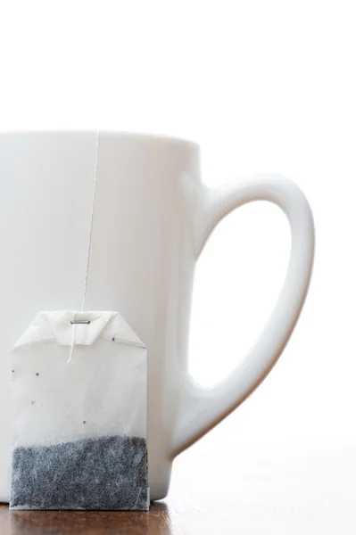 Чайная сумка и чашка — стоковое фото