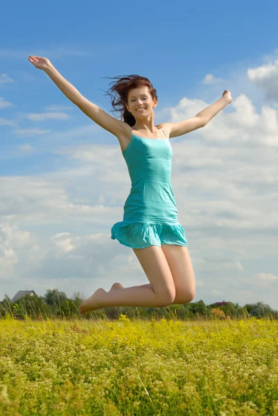 Lycklig flicka hoppar Stockfoto
