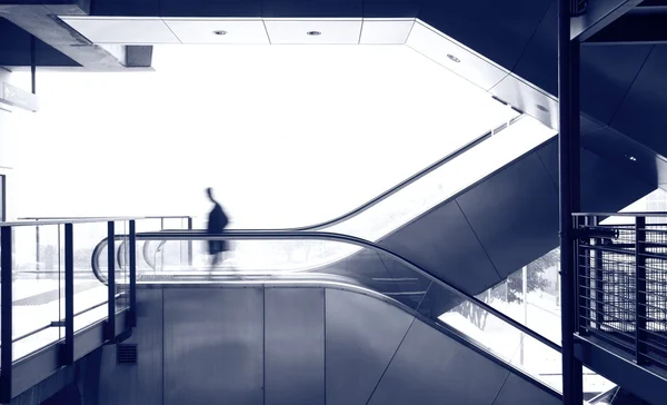 Hombre de negocios se mueven en escaleras mecánicas —  Fotos de Stock