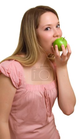 Jeune belle fille mange une pomme verte 