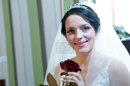Jeune belle mariée avec rose rouge 