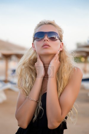 Sexy fille blonde avec des lunettes sur une plage 