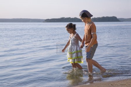 Garçon et fille marchant le long du lac 
